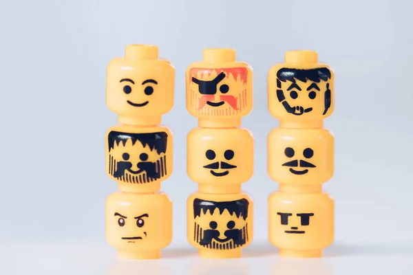 KYIV, UKRAINE - 15 MARS 2019 : têtes jaunes de figurines lego avec différents visages en rangs sur blanc — Photo de stock