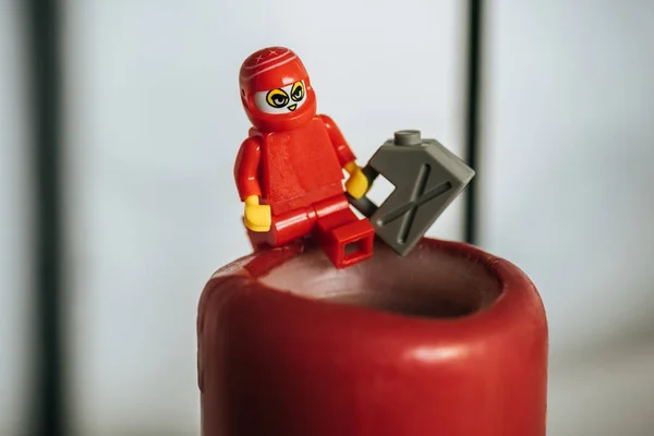 QUIIV, UCRÂNIA - MARÇO 15, 2019: visão de perto da estatueta de lego de plástico com lata de gasolina na vela — Fotografia de Stock