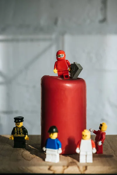 KYIV, UCRANIA - 15 DE MARZO DE 2019: foco selectivo de figurita roja con lata de gasolina y fósforo de pie sobre vela roja - foto de stock