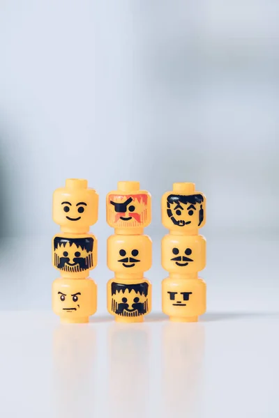 KYIV, UCRANIA - 15 DE MARZO DE 2019: cabezas amarillas de figuras de lego con varias caras en filas - foto de stock