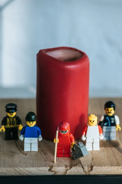 KYIV, UCRANIA - 15 DE MARZO DE 2019: Estatuilla roja con lata de gasolina y fósforo de pie con personajes lego cerca de la vela - foto de stock