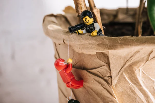 KYIV, UKRAINE - 15 MARS 2019 : figurine de lego en plastique corde d'escalade tandis que le policier jouet crie dans l'embout buccal — Photo de stock