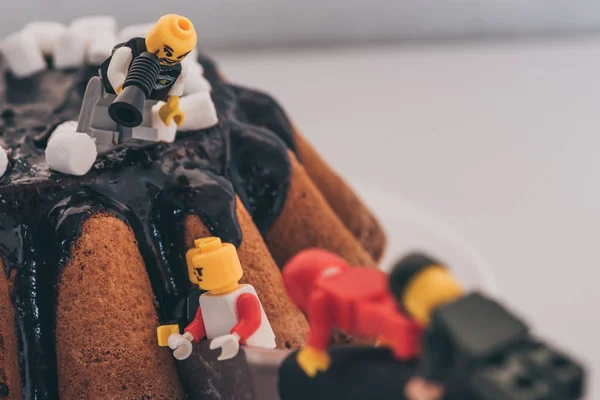 QUIIV, UCRÂNIA - MARÇO 15, 2019: personagem de lego com bocal em pé sobre bolo e gritando com figuras cortando bolo — Fotografia de Stock