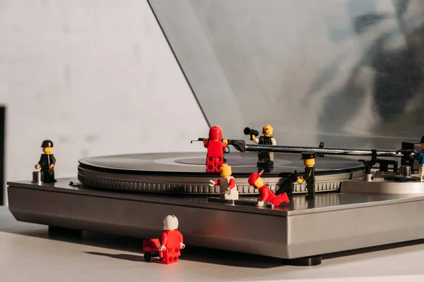 KYIV, UKRAINE - MARCH 15, 2019: colorful plastic lego figurines fixing vinyl record player — Stock Photo