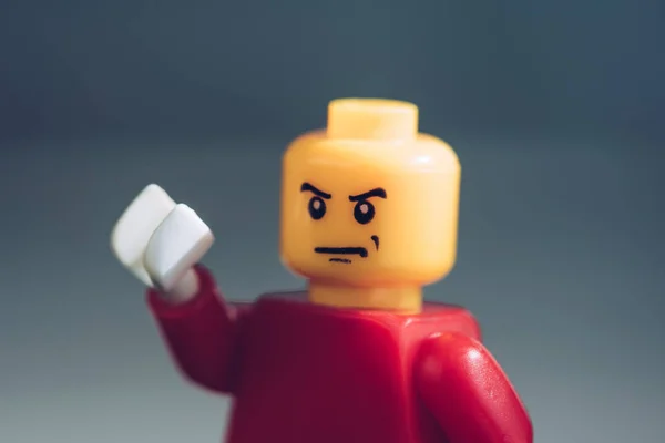 KYIV, UKRAINE - MARCH 15, 2019: close up of red lego figure with angry face gesturing on grey — Stock Photo