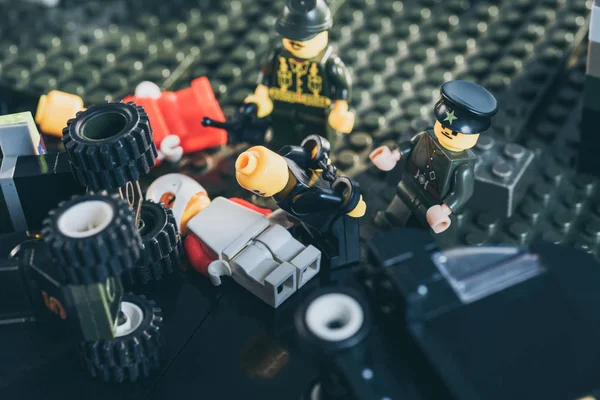 QUIIV, UCRÂNIA - MARÇO 15, 2019: policiais figurinhas em uniforme e chapéus prendendo figura de lego em preto — Fotografia de Stock