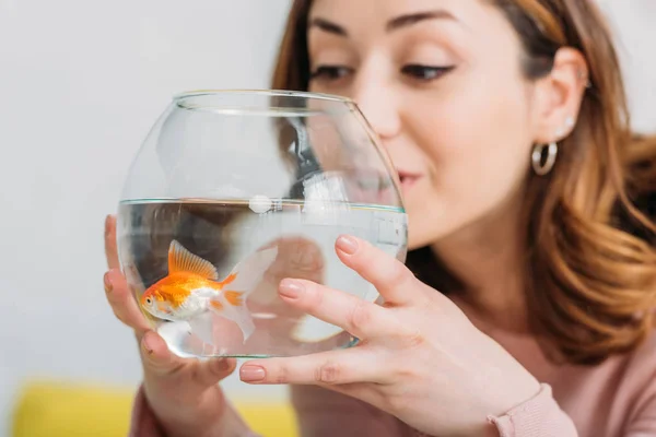 Красивая молодая женщина держит аквариум с яркой золотой рыбой — стоковое фото
