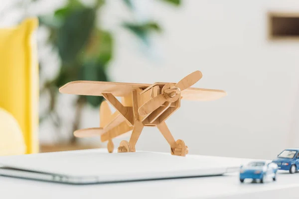 Selective focus of wooden plane model and miniature car models — Stock Photo