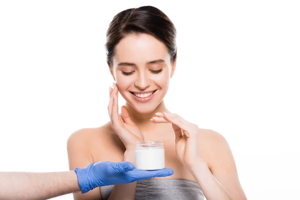 Cropped view of plastic surgeon in latex glove holding container with cosmetic cream near happy girl isolated on white — Stock Photo