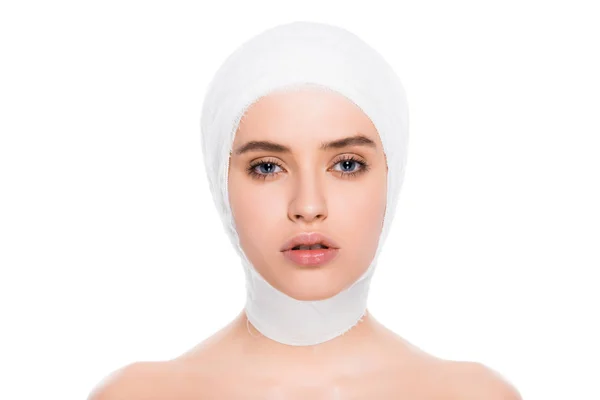 Schöne junge Frau mit bandagiertem Kopf, die auf weiß isoliert in die Kamera blickt — Stockfoto