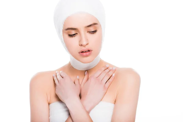 Jeune femme avec tête bandée avec bras croisés après une chirurgie plastique isolée sur blanc — Photo de stock