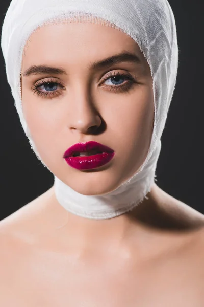 Nahaufnahme eines schönen Mädchens mit bandagiertem Kopf, das in die Kamera schaut, isoliert auf grau — Stockfoto
