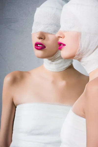 Mirror reflection of girl with bandaged head and eyes on grey — Stock Photo