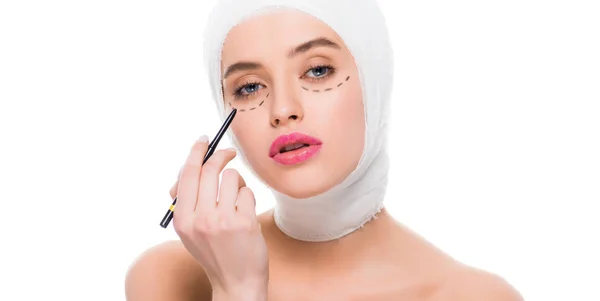 Tiro panorâmico de mulher jovem com marcas no rosto e cabeça enfaixada segurando caneta marcador isolado no branco — Fotografia de Stock