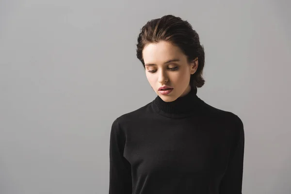 Jeune femme en pull noir isolé sur gris — Photo de stock