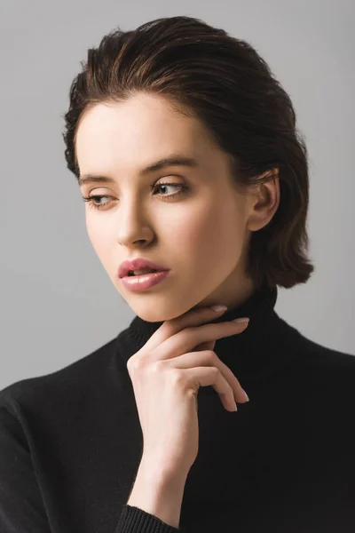 Nachdenkliche junge Frau in schwarzem Pullover isoliert auf grau — Stockfoto