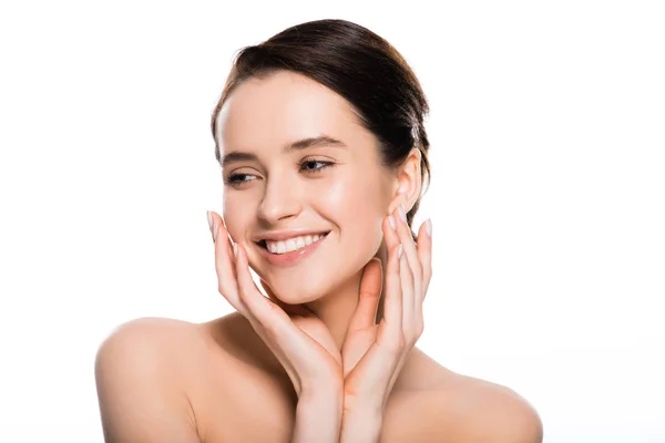 Cheerful young brunette woman touching face isolated on white — Stock Photo