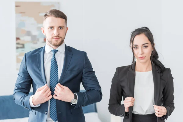 Handsome bearded man and attractive brunette woman looking at camera — Stock Photo