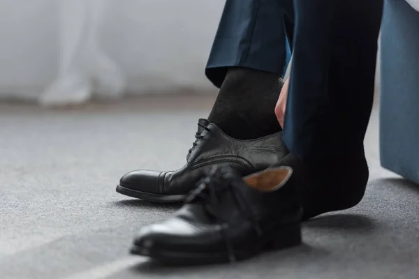 Cropped view of man wearing black shoe at home — Stock Photo