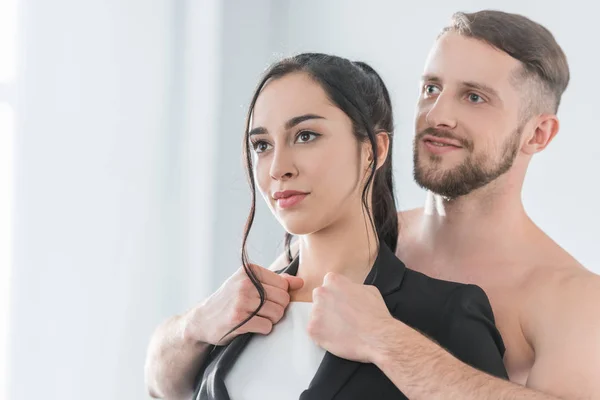 Happy bearded man touching formal wear of brunette woman — Stock Photo