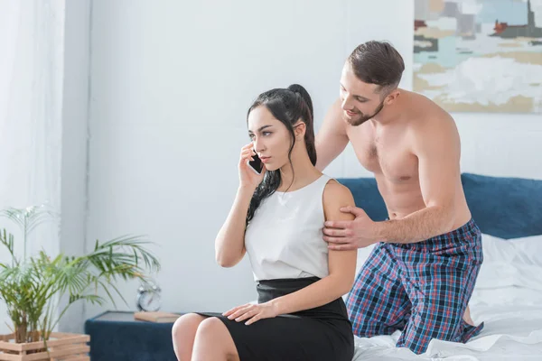 Muskulöser bärtiger Mann berührt attraktive Frau im Smartphone-Gespräch — Stockfoto