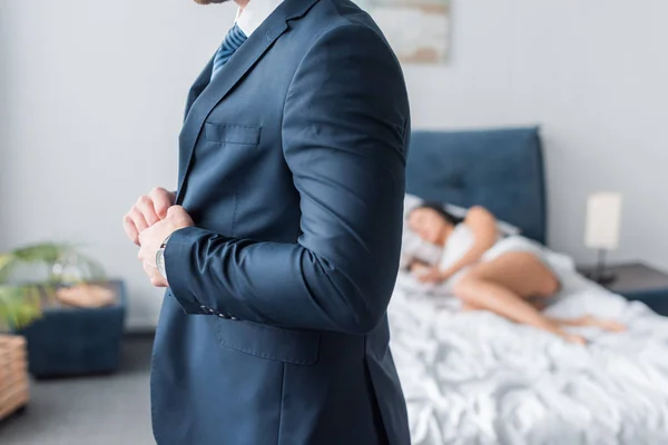 Обрізаний вид чоловіка торкається офіційного одягу біля сплячої жінки — стокове фото