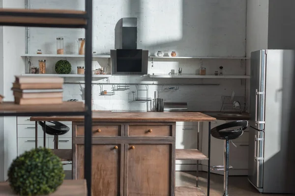 Luz solar en cocina moderna con sillas de mesa de madera y nevera - foto de stock