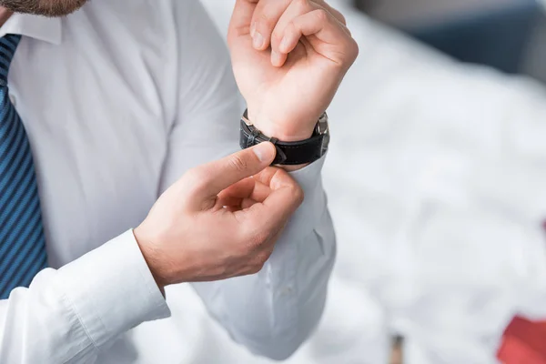 Vista cortada de homem de negócios em desgaste formal tocando relógio na mão — Fotografia de Stock