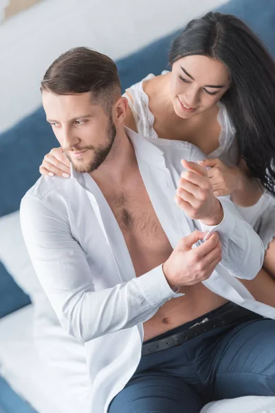 Alegre morena mujer mirando guapo hombre usando camisa - foto de stock