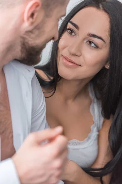 Selective focus of attractive brunette girl looking at bearded boyfriend at home — Stock Photo