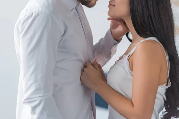Обрезанный вид брюнетки женщина трогает белую рубашку на бойфренд — стоковое фото