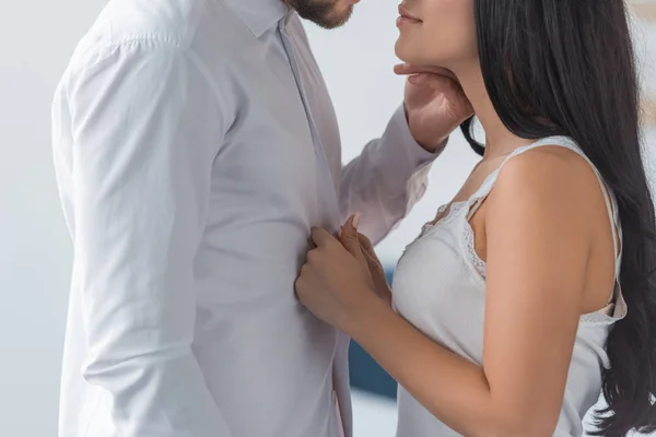 Recortado vista de morena mujer tocando blanco camisa en novio - foto de stock