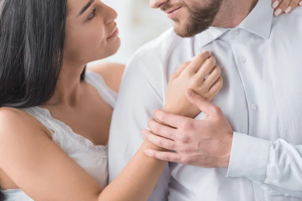 Recortado vista de la joven mujer abrazando alegre novio en camisa blanca - foto de stock