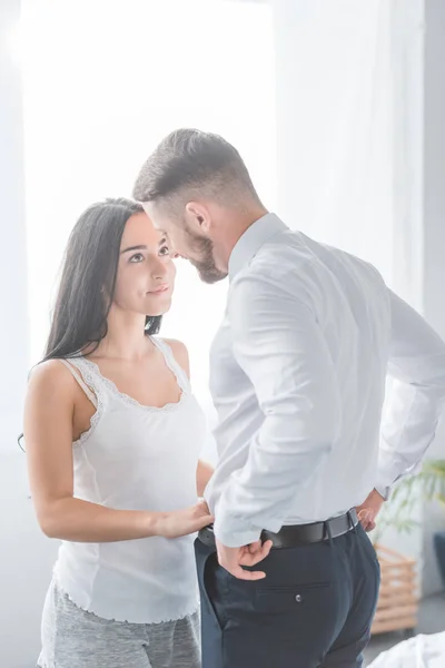 Menina morena bonita tocando calças de namorado bonito na camisa branca — Fotografia de Stock