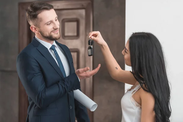 Happy brunette girlfriend giving key to handsome bearded man — Stock Photo