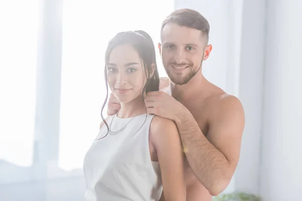 Alegre muscular homem de pé com feliz morena namorada — Fotografia de Stock