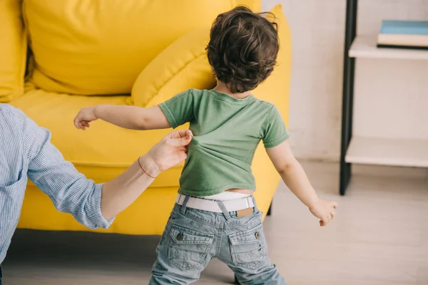 Vue recadrée de la mère jouant avec son fils dans le salon — Photo de stock