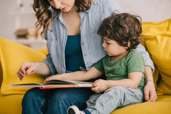 Vue recadrée de mère et fils lecture livre ensemble — Photo de stock