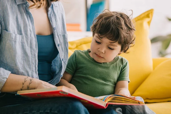 Vista cortada de mãe e filho lendo livro juntos — Fotografia de Stock