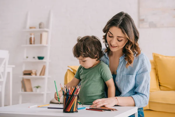 Disegno madre e figlio con matite a colori in salotto — Foto stock