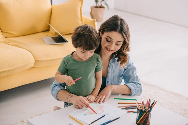 Disegno madre e figlio con matite a colori in salotto — Foto stock