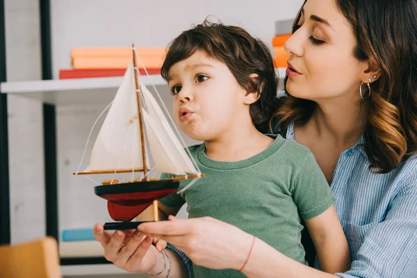 Mãe e criança surpresa com navio de brinquedo na sala de estar — Fotografia de Stock