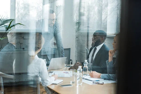 Selective focus of successful business coach near multicultural colleagues — Stock Photo