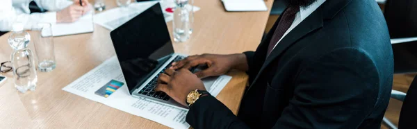 Tiro panorâmico do homem americano africano usando laptop com tela em branco — Fotografia de Stock