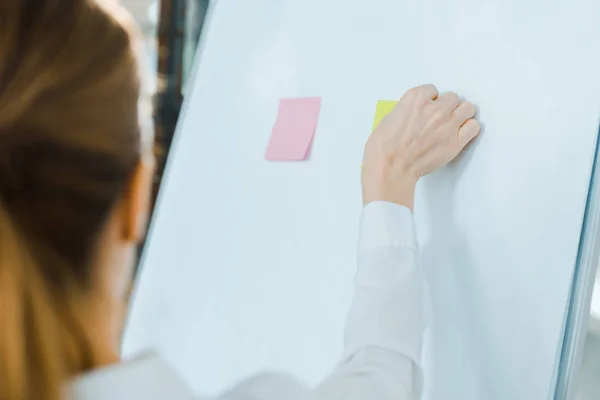 Selective focus of business coach putting sticky notes on white board — Stock Photo