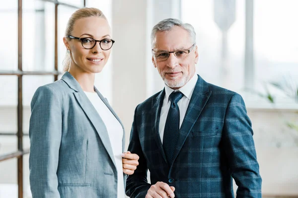 Femme d'affaires gaie et homme d'affaires dans des lunettes de vue regardant la caméra — Photo de stock