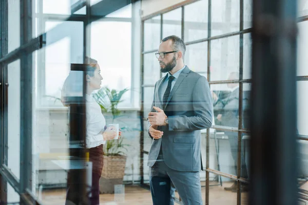 Selektiver Fokus des bärtigen Geschäftsmannes im Gespräch mit attraktiven Mitarbeitern — Stockfoto