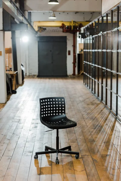 Chaise confortable noire sur sol en bois dans un bureau moderne — Photo de stock