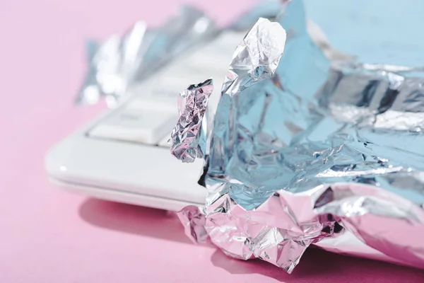 Messa a fuoco selettiva della tastiera del computer avvolto in lamina d'argento sul rosa, concetto di barra di cioccolato — Foto stock