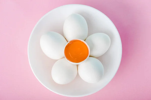 Top view of plate with flower made of eggs and egg yolk on pink — Stock Photo
